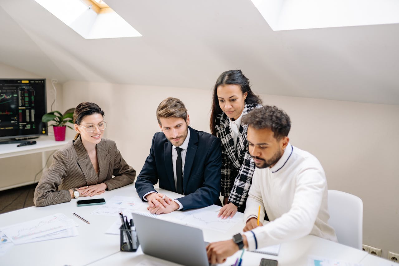 A diverse team of professionals collaborating and discussing work in a modern office setting.